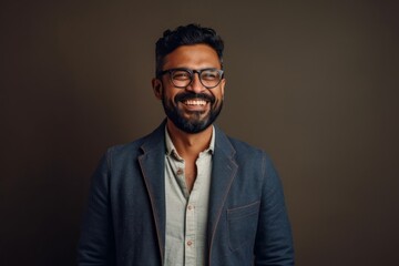 Obraz premium Lifestyle portrait of an Indian man in his 30s in a minimalist background