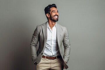 Fototapeta premium Lifestyle portrait of an Indian man in his 30s in a minimalist background