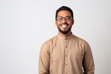Medium shot portrait of an Indian man in his 30s wearing hijab in a minimalist background