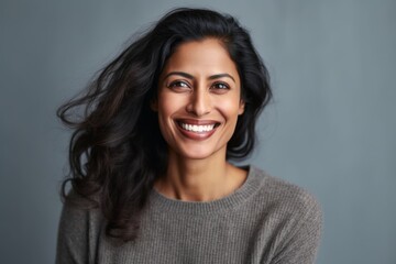Fototapeta premium Close-up portrait of an Indian woman in her 40s in a minimalist background