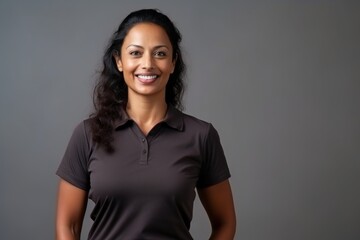Medium shot portrait of an Indian woman in her 40s wearing a sporty polo shirt in a minimalist background