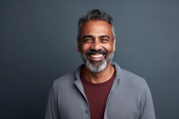 Medium shot portrait of an Indian man in his 40s in a minimalist background