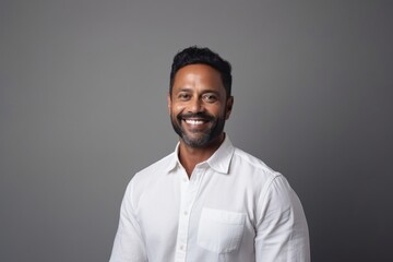 Fototapeta premium Medium shot portrait of an Indian man in his 40s in a minimalist background