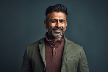 Fototapeta premium Lifestyle portrait of an Indian man in his 40s in a minimalist background