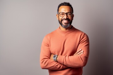 Obraz premium Lifestyle portrait of an Indian man in his 40s in a minimalist background