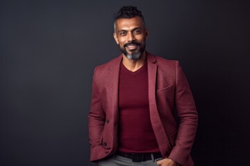 Fototapeta premium Lifestyle portrait of an Indian man in his 40s in a minimalist background