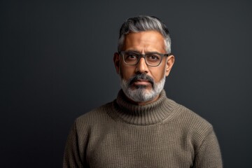 Fototapeta premium Lifestyle portrait of an Indian man in his 50s in a minimalist background