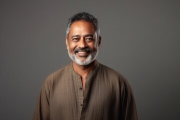 Obraz premium Medium shot portrait of an Indian man in his 50s in a minimalist background