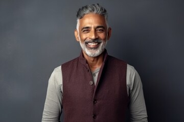 Medium shot portrait of an Indian man in his 50s in a minimalist background