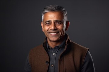 Medium shot portrait of an Indian man in his 50s in a minimalist background