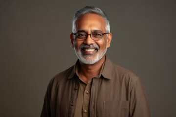 Obraz premium Medium shot portrait of an Indian man in his 60s in a minimalist background