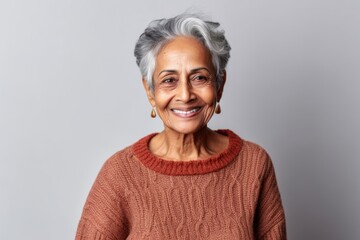 Lifestyle portrait of an Indian woman in her 70s in a minimalist background