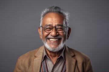 Obraz premium Medium shot portrait of an Indian man in his 70s in a minimalist background