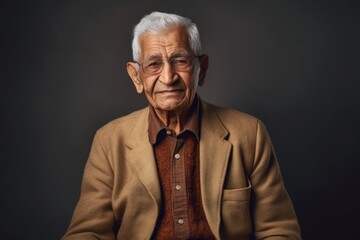 Obraz premium Lifestyle portrait of an Indian man in his 90s in a minimalist background