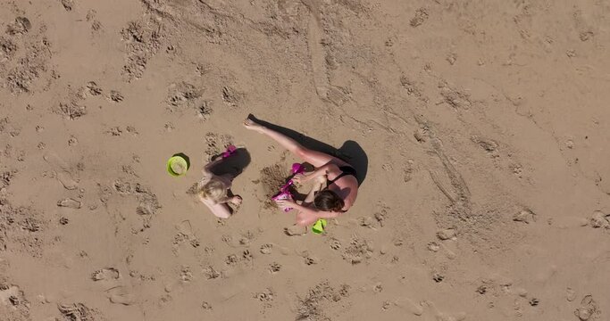 Mother and child building a sand castle on the beach 4k