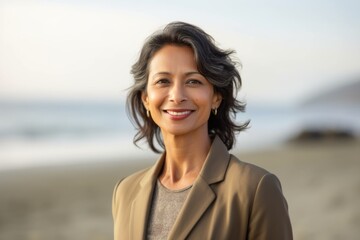 Portrait of a smiling mature businesswoman standing on the beach.