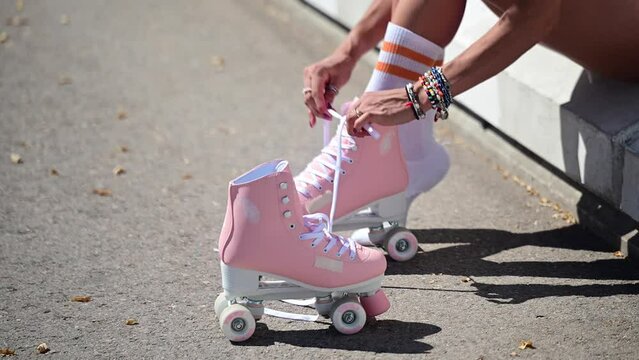 Happy african american woman in casual clothes skates on asphalt on a sunny day