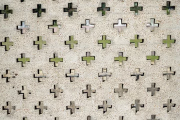 Tuinposter Close-up view of a wall adorned with religious crosses. © Emilia