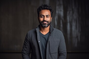 Obraz premium Portrait of a handsome Indian man with a beard in a gray jacket.