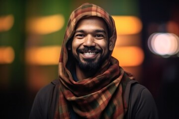 Portrait of a smiling arabic man wearing scarf at night