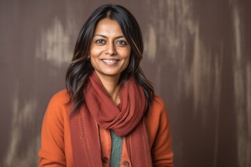 Lifestyle portrait of an Indian woman in her 40s in an abstract background