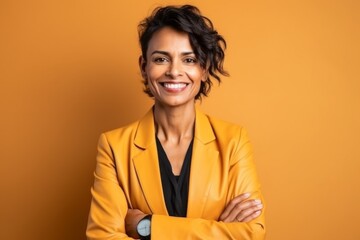 smiling african american woman in yellow jacket with crossed arms on yellow background