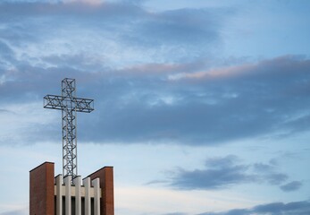 Krzyż na wieży kościoła na tle niebieskiego nieba