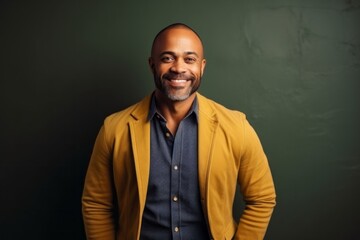 Fototapeta premium Portrait of smiling african american male teacher standing against chalkboard