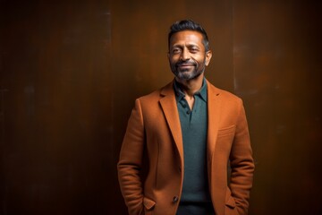 Obraz premium Portrait of a handsome Indian man wearing a coat and smiling at the camera