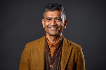 Obraz premium Portrait of a handsome Indian man in a coat on a dark background