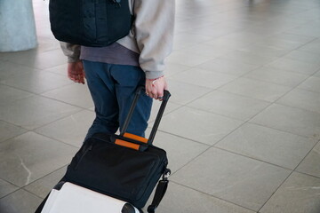 Young person hauling their suitcase at the airport.