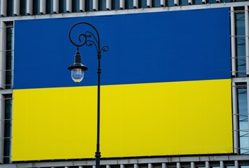 Latarnia uliczna na tle dużej flagi Ukrainy - obrazy, fototapety, plakaty