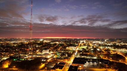 Aerial shot of the illuminated cityscape a midwest city with the pink sunset in the background