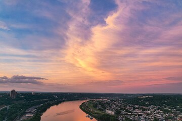 Obraz premium Scenic view of a city river surrounded with buildings during a colorful sunset
