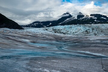 the top two mountains are covered in snow and ice from the glacier