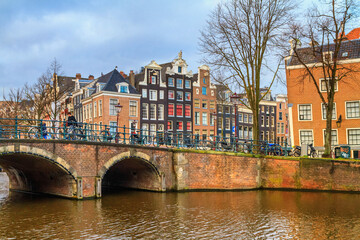 Cityscape on a sunny winter day - view of the bridge and canal in the historic center of Amsterdam, The Netherlands
