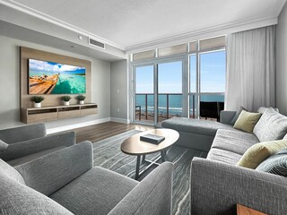 living room with large window and ocean view and sofas