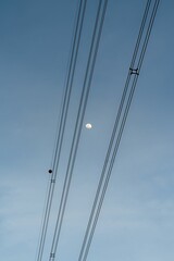 Fototapeta premium a full moon with some power lines in the sky and trees