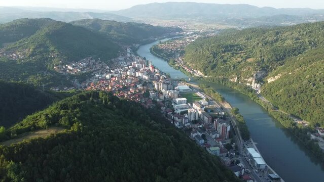Aerial video of the city surrounded by a river and mountains covered with trees, zvornik