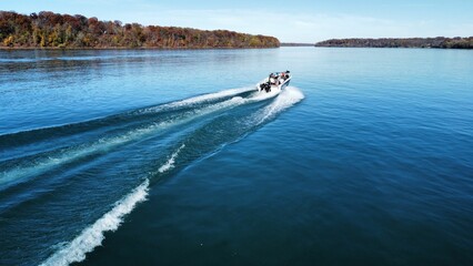 Obraz premium Aerial view of a motorboat sailing in the sea near the shore on a sunny day
