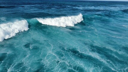 Aerial view of turquoise waves in the sea on a sunny day