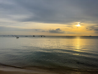 Stunning sunset illuminating the horizon, highlighting the silhouettes of several boats