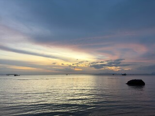 Fototapeta na wymiar Tranquil beach scene with a picturesque sunset illuminating the horizon