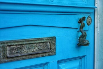 Closeup of an abstract doorknob on a bright blue door