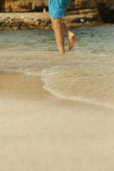 Male walking on the beach shore