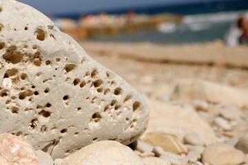 Sun-drenched beach in Alicante, Spain, featuring textured sea rocks in an array of shapes
