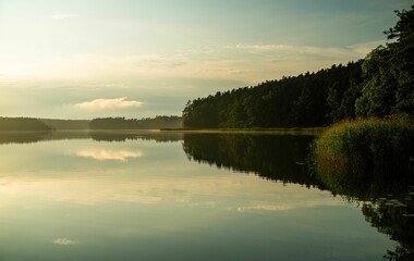 Beautiful landscape of the horizon with the sun setting over the calm water of a lake