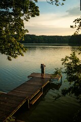 Beautiful couple embracing on a pier overlooking a tranquil lake