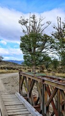 Fototapeta premium View of a railway bridge over a gravel road, with a clear blue sky above