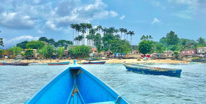 Beach scene featuring palm trees and boats near the shore. Sao Tome and Principe.